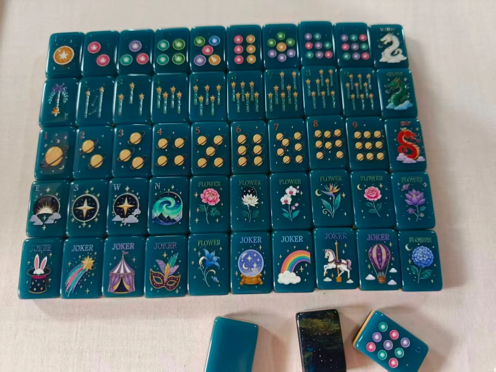 Midnight Galaxy American Mah Jongg set — teal faces, planet dots, and galaxy-pour backs